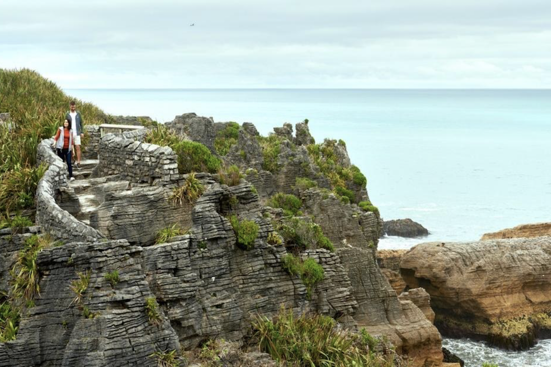 People walking down stairs in front of ocean